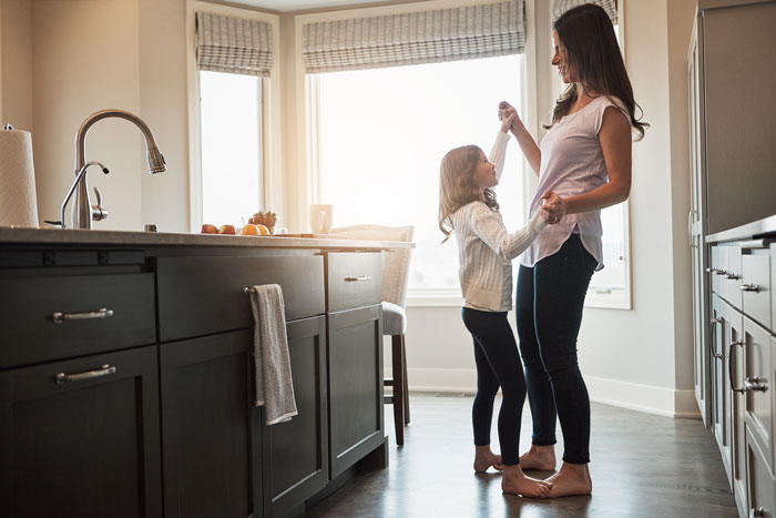 Mom and daughter standing in kitchen